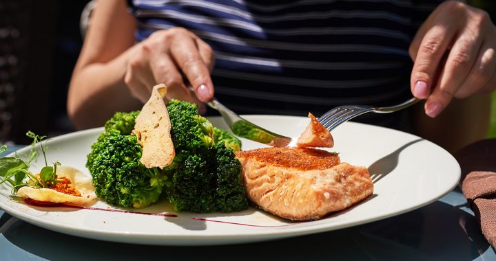 A person enjoying a salmon dinner.