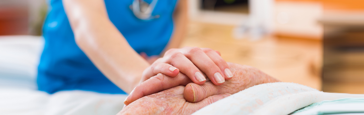 nurse holding a patients hand - national nurses week mercy health