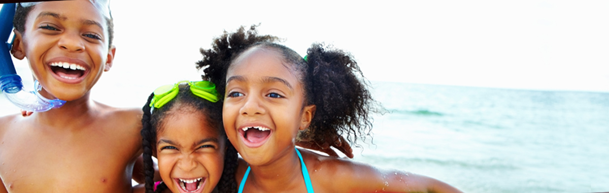 three children playing in the ocean - preventing skin cancer