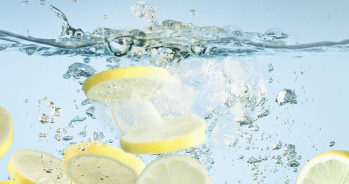 slices of lemon splash into fresh water _ benefits of drinking lemon water