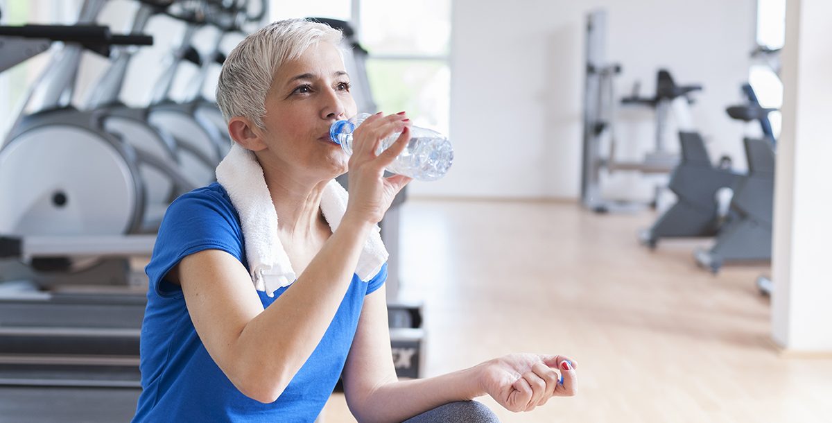 A woman drinking water during her workout.