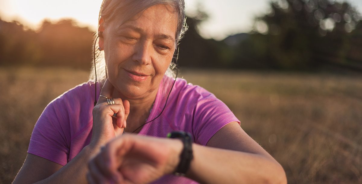 A woman checking her pulse while on a walk.