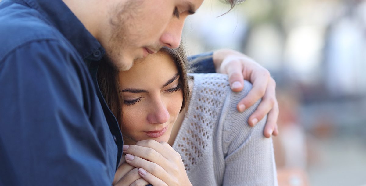 A person comforting a loved one while discussing suicide.