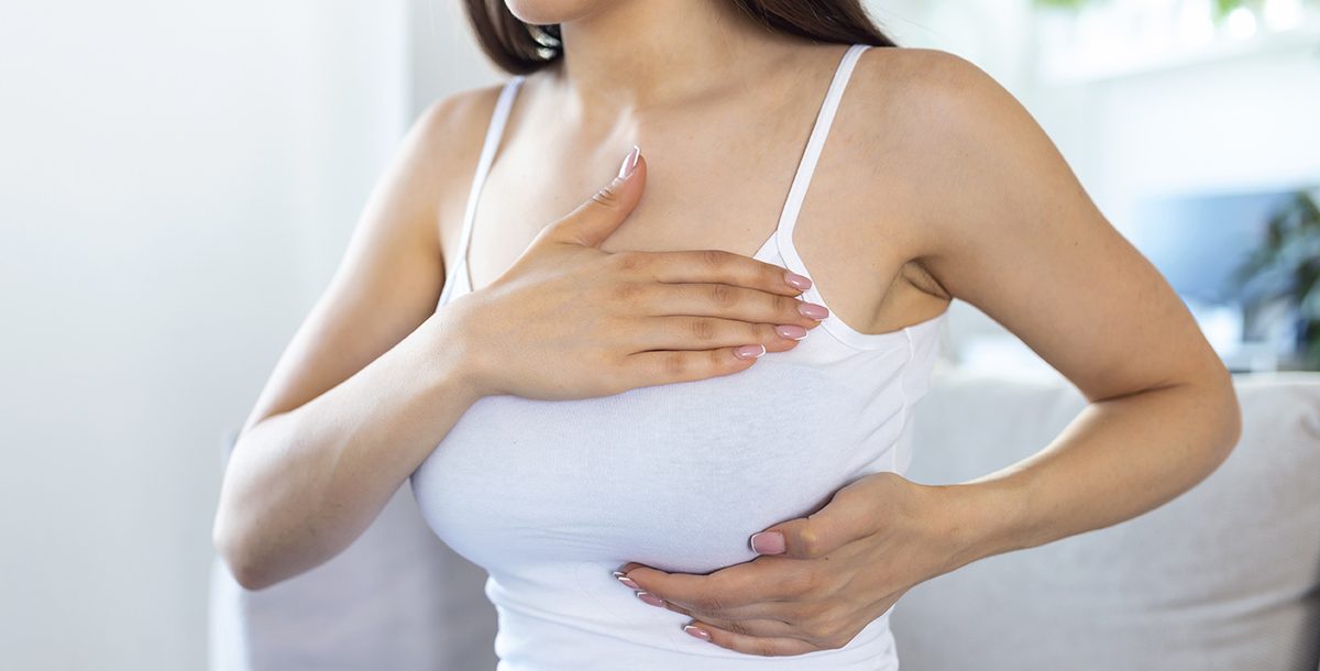 A woman performing a breast self-exam.