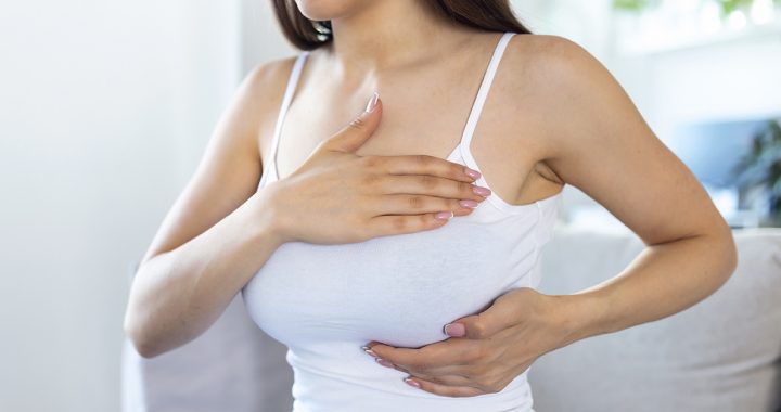 A woman performing a breast self-exam.