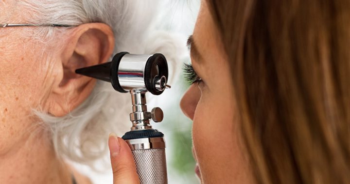 Female ENT provider examining an older female patient's ear