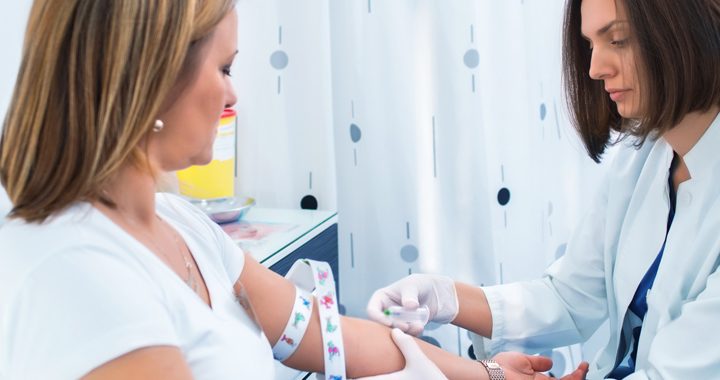 One woman taking blood from another for a fasting blood glucose test