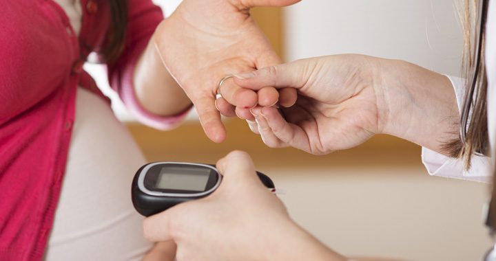 close-up of healthcare worker using blood glucose meter to test pregnant woman's blood sugar - gestational diabetes