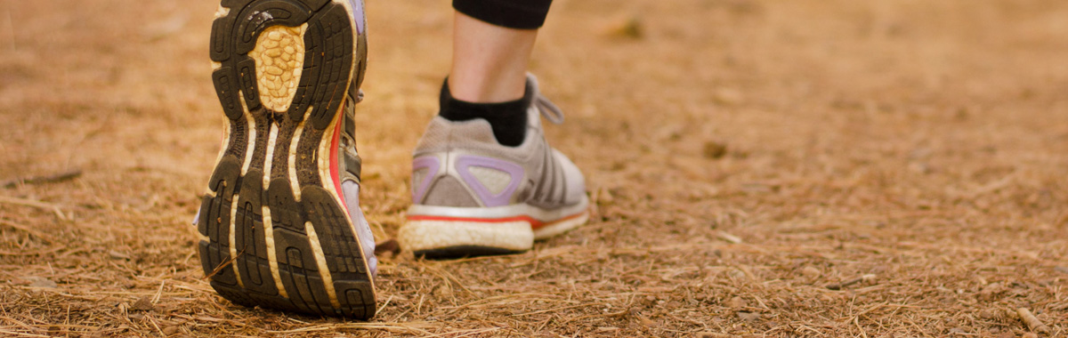 View of person's gymshoes walking away - walking strides