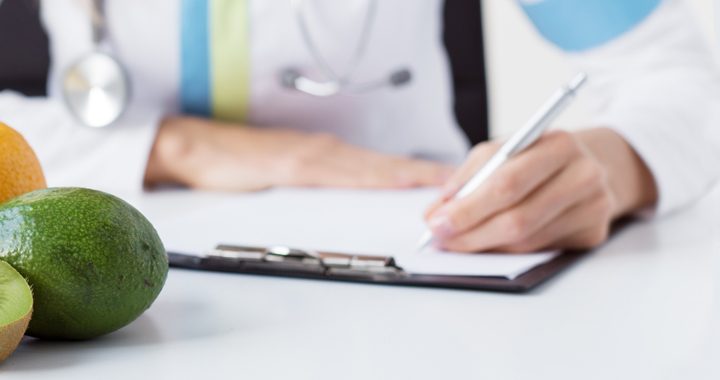 Provider sitting with paper and pen at table with fruits planning a diet for after surgical weight loss