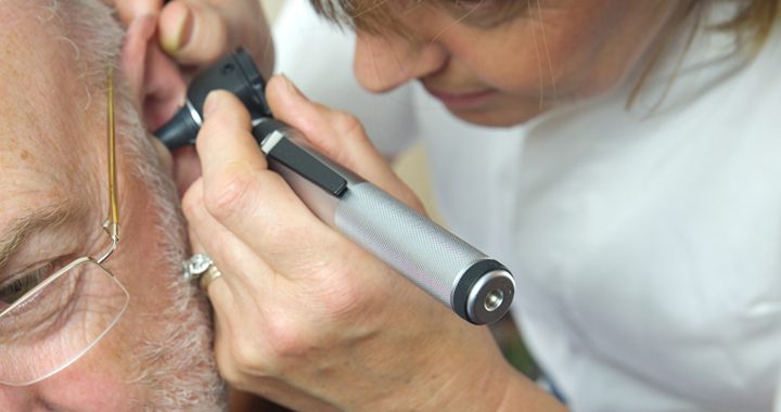 Provider looking in patient's ear for ear wax