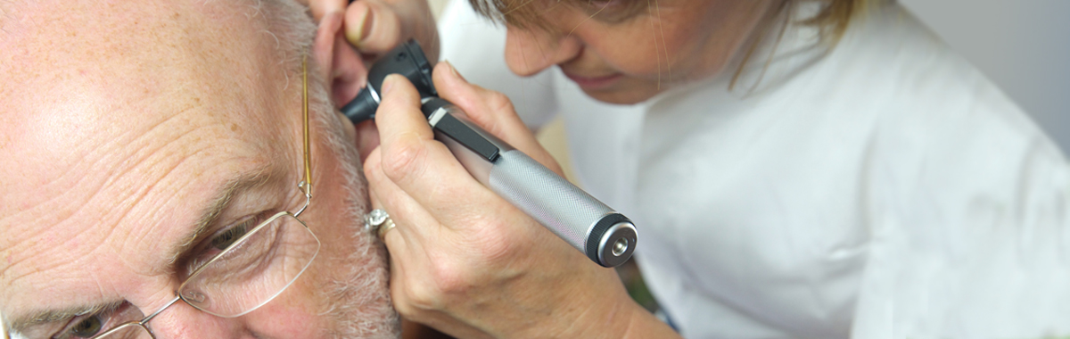 Provider looking in patient's ear for ear wax