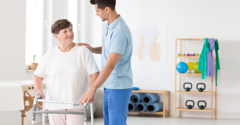 woman with a walker going through rehabilitation for a hip replacement