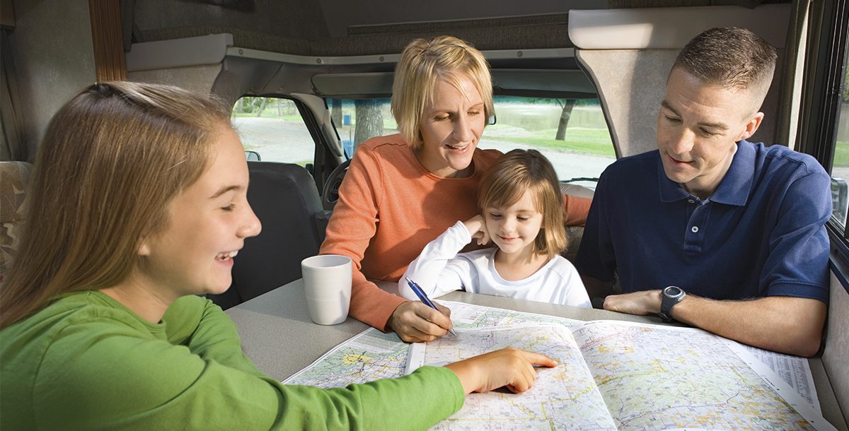 Family of Four looking at a map researching their spring break trip