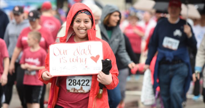 participant of Heart Mini race holding up a sign