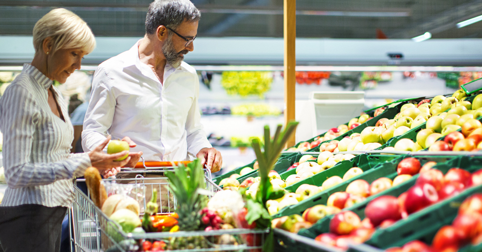 couple looking at produce section of the grocery store