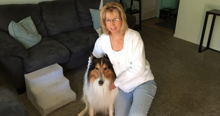 Rebecca, a trigeminal neuralgia patient, poses with her brown and white dog