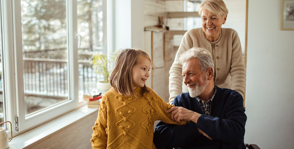 Grandmother, grandfather and granddaughter inside their house.