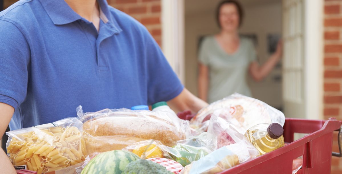 Delivery man dropping off groceries to a house.