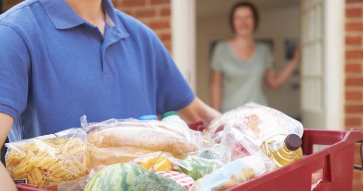 Delivery man dropping off groceries to a house.