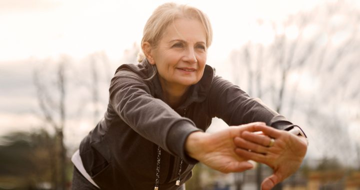 Woman practicing stretching exercises outside.