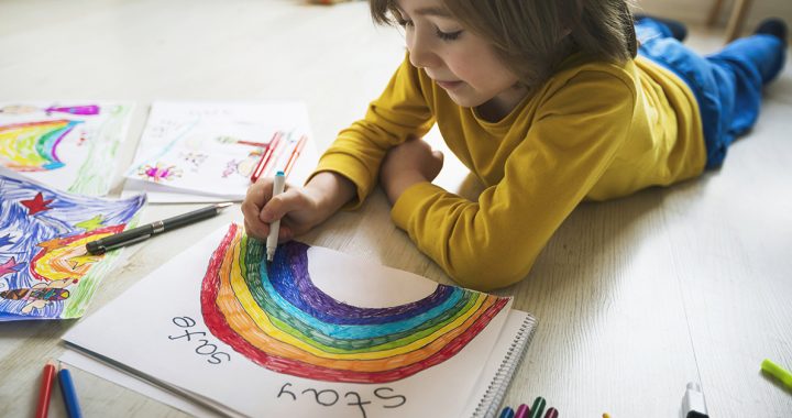 Child coloring a rainbow picture to help spread messages of hope during COVID-19.