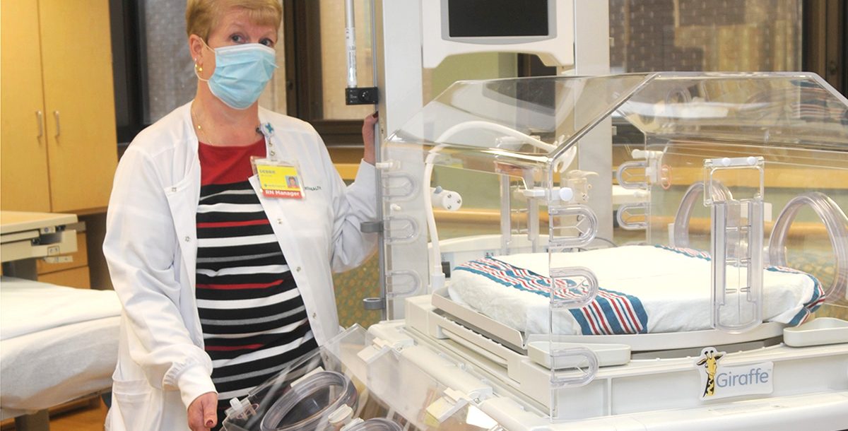 Debbie Pollander, RN, standing next to the infant care station.