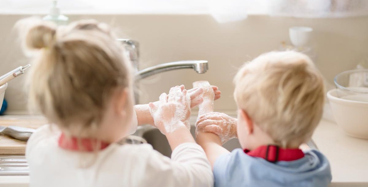 Two children practicing proper handwashing during COVID-19.