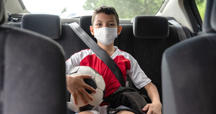 A boy going to his soccer game wearing a face mask during COVID-19.