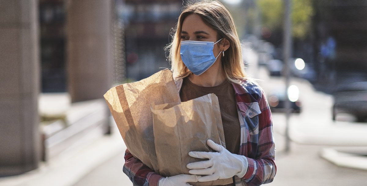 A woman shopping with a face mask on during the summer.