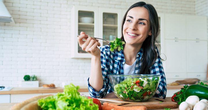 A woman enjoying a salad as part of her plant-based diet.