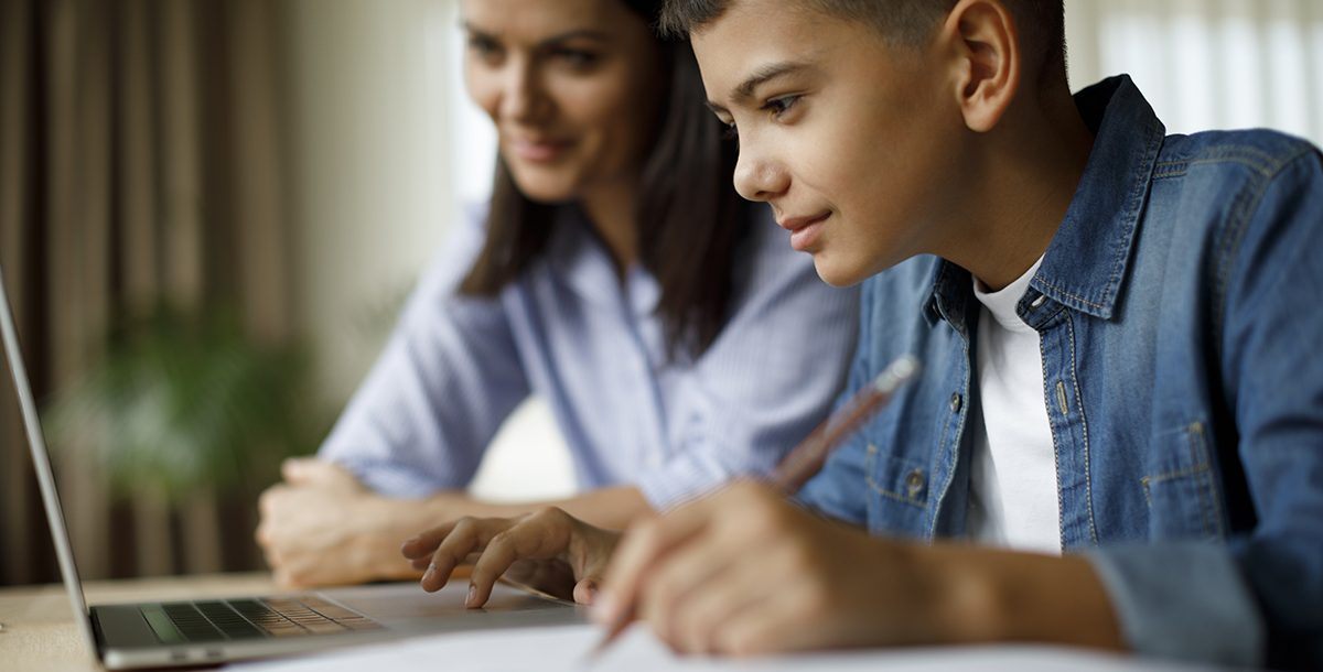 A mother helping her son with e-learning at home during COVID-19.