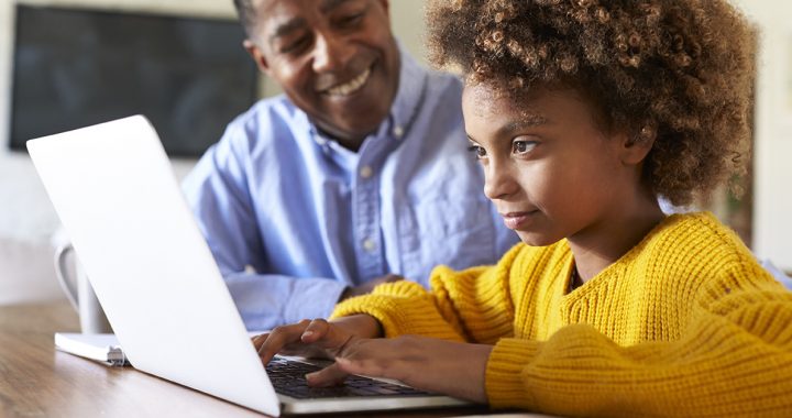 A father helping his daughter with elearning at home during COVID-19.