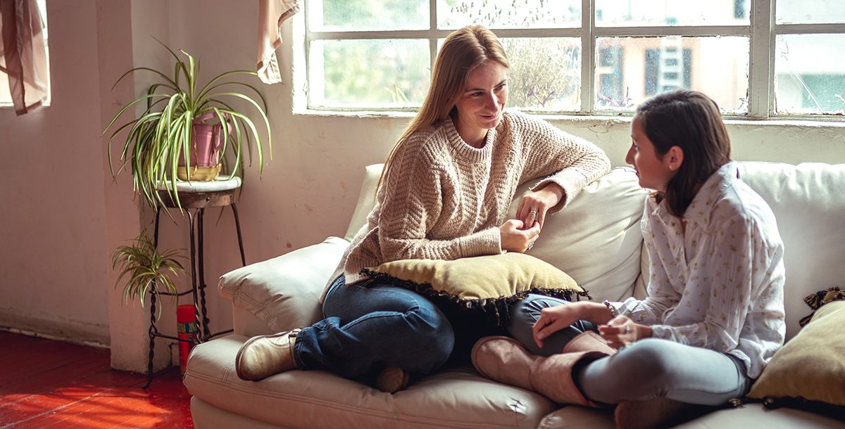 A mother having a serious discussion with her daughter at home.