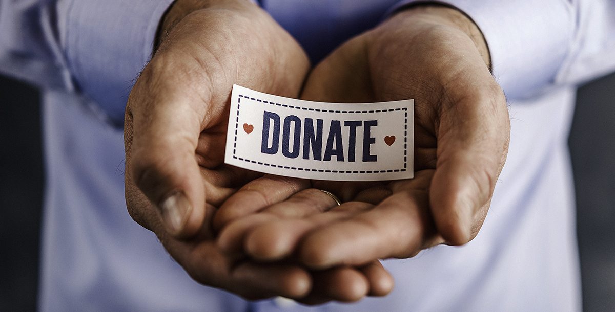 A person holding a donate sign.