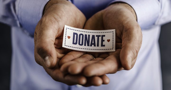 A person holding a donate sign.