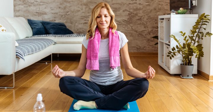 A woman practicing yoga at home.