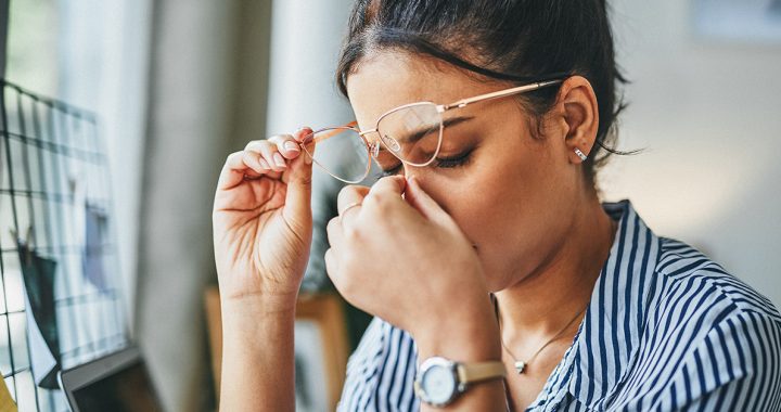 A women touching her face while stressed.