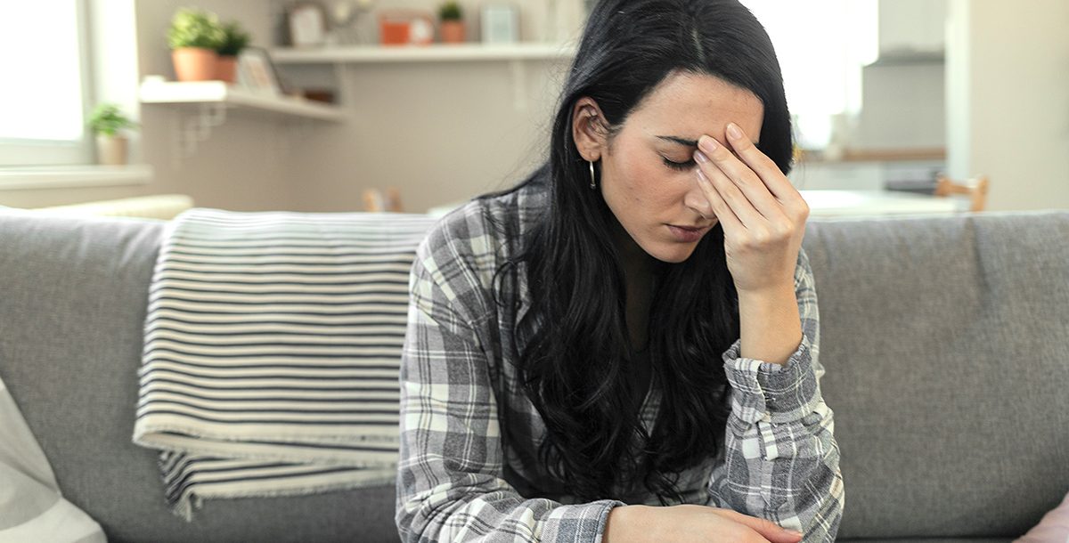 A woman experiencing COVID-19 vaccine side effects.