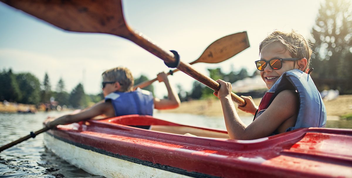 A child kayaking with their parent.