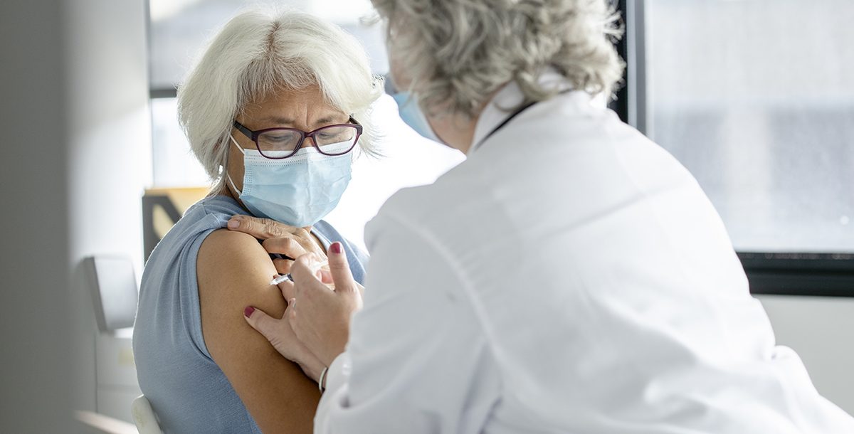 A woman getting her flu and COVID-19 vaccines.