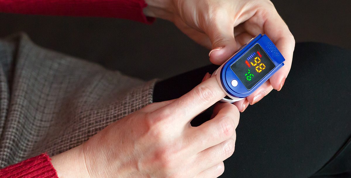 A person using a pulse oximeter.