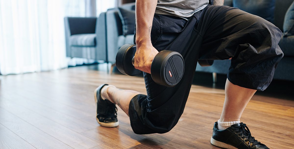 A man doing lunges at home.